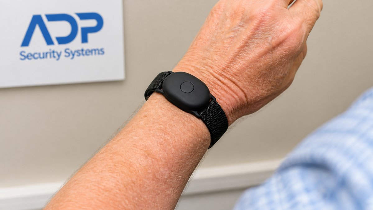 Diagram showing how to prevent false alarms on fall sensors by wearing the device snugly above the wrist bone